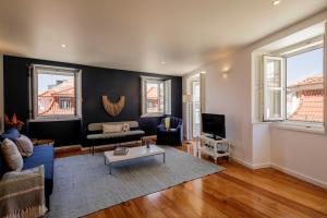 a living room with a couch and a table at Chiado Premium Two Bedroom Apartment by Les Deux Mariettes in Lisbon