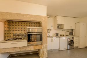 a kitchen with a stove top oven next to a refrigerator at Chiado Premium Two Bedroom Apartment by Les Deux Mariettes in Lisbon