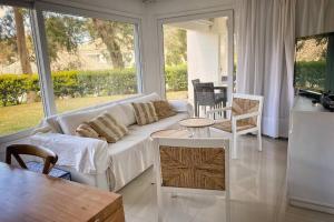 a living room with a white couch and a table at Green Park 2 Ambientes en PB con Jardín y Parrillero in Punta del Este