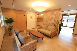 sala de estar con sofá, sillas y mesa en 白浜の宿　 蘭, en Shirahama