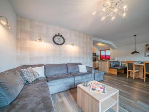a living room with a couch and a clock on the wall at Penthouse Janita in Westendorf
