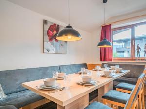 comedor con mesa de madera y sillas en Penthouse Janita, en Westendorf