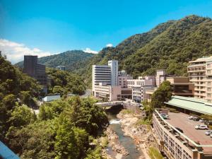 a city with a river and mountains in the background at Shogetsu Grand Hotel in Jozankei