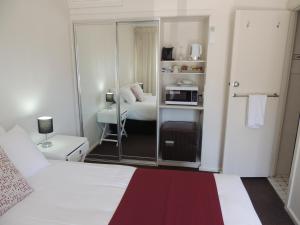Habitación de hotel con cama y espejo en Comfort Inn Premier en Coffs Harbour