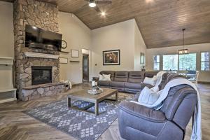 a living room with a couch and a stone fireplace at Stylish Show Low House with Expansive Deck! in Show Low
