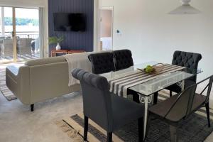 uma sala de estar com um sofá, uma mesa e cadeiras em Waterfront Condo with 2 Pools and Boat Slip! em Lake Ozark