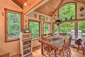 a dining room with a table and chairs and windows at Beautiful Jay Peak Home Near Creek and Waterfalls! in Jay