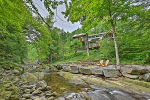 a house on a hill next to a stream at Beautiful Jay Peak Home Near Creek and Waterfalls! in Jay