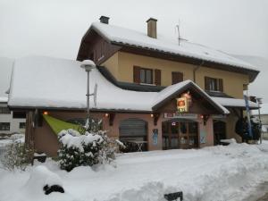 a building with snow on the roof of it at Le Grand Chatelard HÔTEL BAR RESTAURANT in Sainte-Marie-de-Cuines