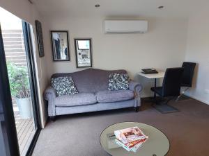 a living room with a couch and a table at Adelphi Apartment 6 Riverview 2 BDRM or 6A King Studio Riverview both with balconies in Echuca