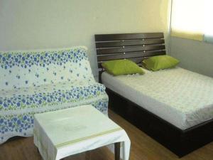 Room in Apartment - Popular Palace in Don Mueang Bangkok في Ban Bang Phang: غرفة نوم بسريرين ومقعد فيها