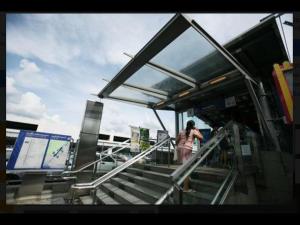 a woman walking up the stairs at a bus stop at Popular Palace in Don Mueang Bangkok in Ban Bang Phang