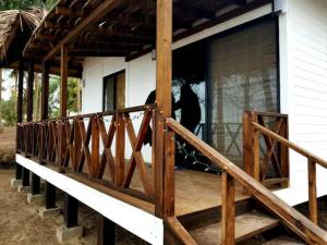 a man standing on the porch of a house at Aldea Suncunu playa y alberca privada en Tuxpan in Tuxpan de Rodríguez Cano