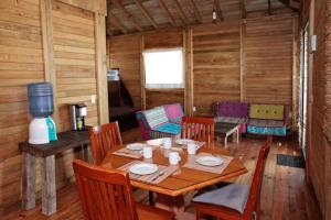 uma sala de jantar em madeira com uma mesa e cadeiras em Aldea Suncunu playa y alberca privada en Tuxpan em Tuxpan de Rodríguez Cano