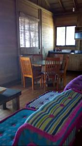 1 dormitorio con 1 cama, mesa y sillas en Aldea Suncunu playa y alberca privada en Tuxpan, en Tuxpan de Rodríguez Cano