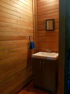 a bathroom with a sink and a wooden wall at Aldea Suncunu playa y alberca privada en Tuxpan in Tuxpan de Rodríguez Cano