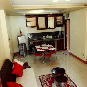 a living room with a couch and a table in a kitchen at Manora Apartment in Talisay