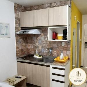 uma pequena cozinha com um lavatório num quarto em Flat Bellagio - suítes econômicas - Ferreira Hospedagens em São Luís