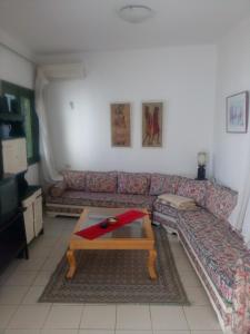 ein Wohnzimmer mit einem Sofa und einem Couchtisch in der Unterkunft House with Wala Garden in Mahdia