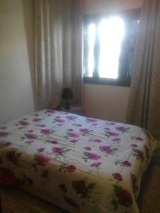 Un dormitorio con una cama con flores rosas. en House with Wala Garden en Mahdia