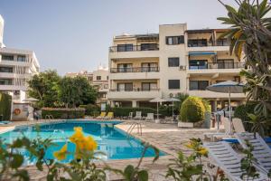 a hotel with a swimming pool in front of a building at One bedroom apartment in Paphos in good location in Paphos