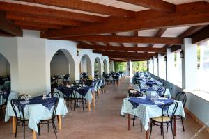 a row of tables and chairs in a restaurant at Villaggio L'Oasi in Isola Capo Rizzuto