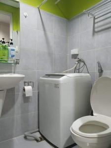 La salle de bains est pourvue de toilettes blanches et d'un lavabo. dans l'établissement Vangie's Place at SEA RESIDENCES, à Manille