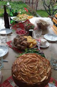 une table avec des assiettes de nourriture et une grande tarte dans l'établissement Guest house Hasmik, à Yeghegnadzor