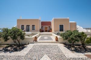 a villa in the desert with trees in front of it at Alba Caldera Villa in Akrotiri