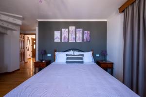 a bedroom with a large white bed with two tables at Alba Caldera Villa in Akrotiri