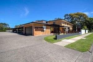 a building with a parking lot in front of it at Beachpark Apartments Coffs Harbour in Coffs Harbour