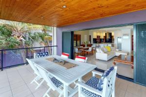 a deck with a table and chairs on a patio at Anchorage Apartments on Hamilton Island by HIHA in Hamilton Island