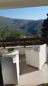 2 witte tafels en stoelen op een balkon met uitzicht bij Casa na Serra 2, Sabugueiro in Sabugueiro