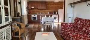 a living room with a red couch and a table at Casa na Serra 2, Sabugueiro in Sabugueiro