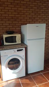 a microwave and a washing machine in a kitchen at Casa na Serra 2, Sabugueiro in Sabugueiro