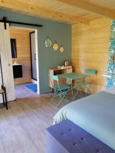 1 dormitorio con 1 cama, mesa y sillas en Moulin Room en Naours
