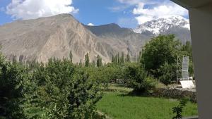 a view of a mountain range with trees and mountains at Hunza Grand Motel in Alīābād