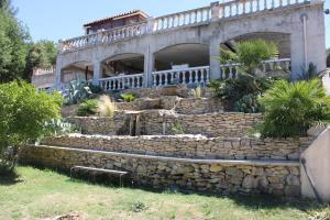 una casa con un muro di pietra e un ponte di les lauriers de Joelle a Peyrolles-en-Provence