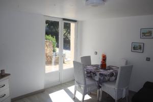 una sala da pranzo con tavolo, sedie e una finestra di les lauriers de Joelle a Peyrolles-en-Provence