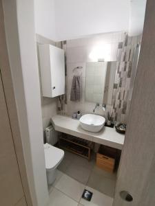 a white bathroom with a sink and a toilet at Luxury Townhouse in Larisa