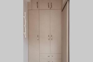 a white closet with white cabinets in a room at Luxury Townhouse in Larisa