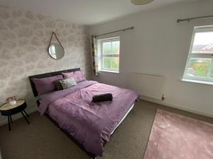 a bedroom with a purple bed and a table at Wilce House in Wellingborough