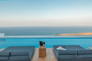 a blue couch sitting next to a blue pool at Oyster Luxury Suites in Imerovigli