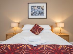 a bedroom with a large white bed with two lamps at The Nags Head Inn in Abercych