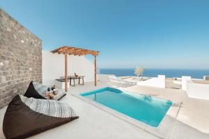 a swimming pool on a patio with the ocean in the background at Oyster Luxury Suites in Imerovigli