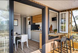 a kitchen and dining area of a tiny house at Camping La Garenne De Moncourt in Rue