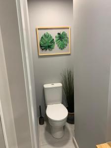 La salle de bains est pourvue de toilettes et de 2 plantes sur le mur. dans l'établissement Hostal Acemar, à Marbella