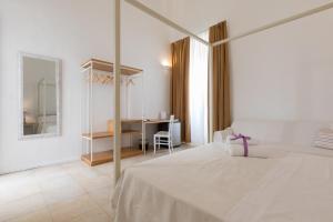 a white bedroom with a bed and a mirror at B&B Dimora San Vincenzo in Gallipoli