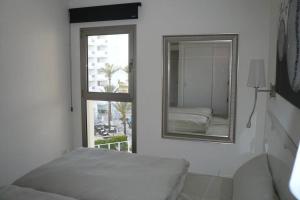 1 dormitorio con espejo, cama y ventana en Modern apartment with stunning sea view en Cala Millor