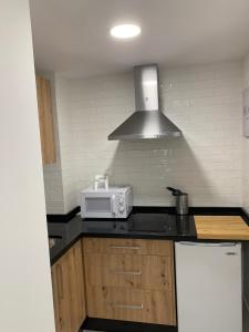 une cuisine avec un comptoir avec un micro-ondes dans l'établissement Hostal Acemar, à Marbella